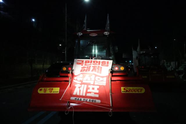 A tractor displays a sign demanding President Yoon Suk Yeols arrest near Namtaeryeong Hill in Seoul Dec 22 2024 AJP Han Jun-gu