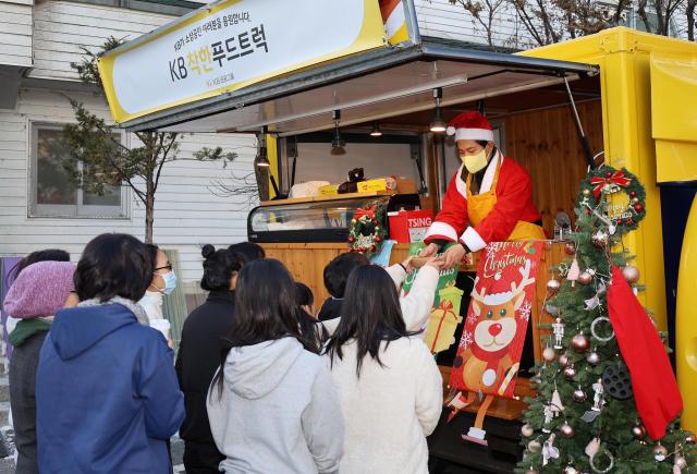 지난 23일 수원시에 위치한 동광원에서 ‘KB착한푸드트럭’ 1호점 대표가 간식을 전달하고 있다