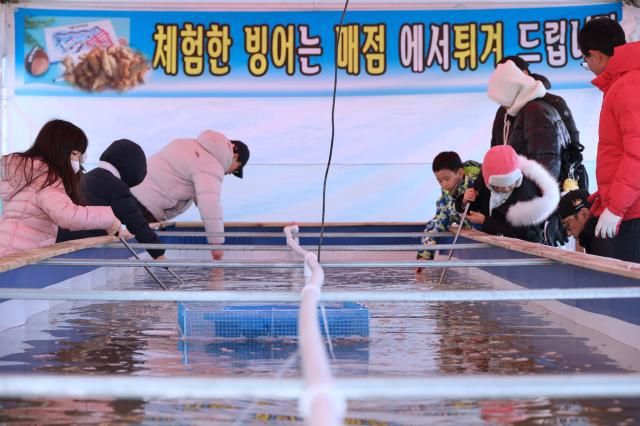 Visitors try hand-net fishing at a snow park in Dongdaemun District Seoul Dec 26 2024 AJP Han Jun-gu