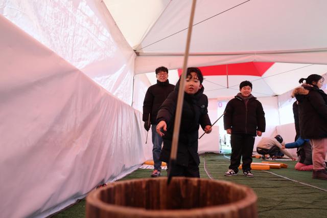 A child participates in traditional Korean folk games at a snow park in Dongdaemun District Seoul Dec 26 2024 AJP Han Jun-gu