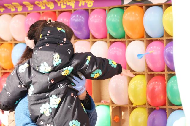 A child plays a balloon popping game at a snow park in Dongdaemun District Seoul Dec 26 2024 AJP Han Jun-gu