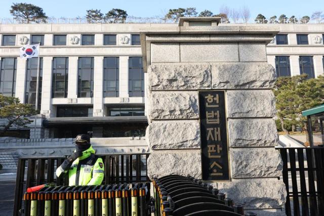 A police officer stands at the entrance of the Constitutional Court of Korea in Seoul on Dec 26 2024 Yonhap