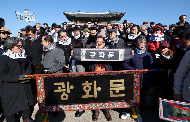  28일 오전 서울 광화문 앞에서 광화문 한글현판달기 추진위원회 등 한글문화단체 회원들이 직접 제작한 한글 현판과 함께 기념촬영을 하고 있다 사진연합뉴스