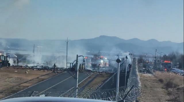 29일 오전 전남 무안국제공항에서 착륙 중이던 항공기가 활주로를 이탈해 울타리 외벽에 충돌했다  사진은 무안공항 인근에서 촬영한 영상을 캡처한 것으로 소방 당국이 사고 수습 작업을 하고 있다 사진연합뉴스