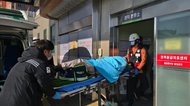 A survivor is transported to a hospital in the southwestern city of Mokpo after a passenger aircraft crashed at Muan International Airport on Dec 29 2024 Yonhap