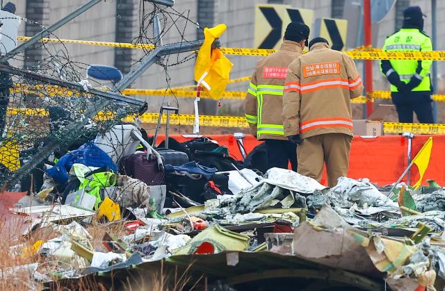 Firefighters inspect Jeju Air plane crash site at Muan Airport in Jeollanam-do South Korea on Dec 30 2024 Yonhap