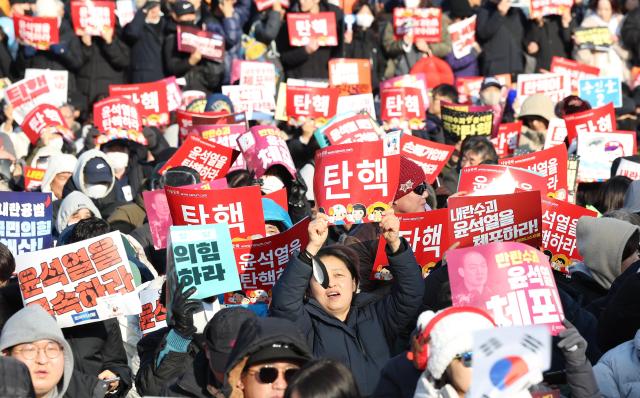 지난 14일 서울 영등포구 여의도 국회 앞에서 열린 윤석열 대통령 탄핵 촉구 집회에서 참석자들이 손팻말을 들고 있다 사진연합뉴스