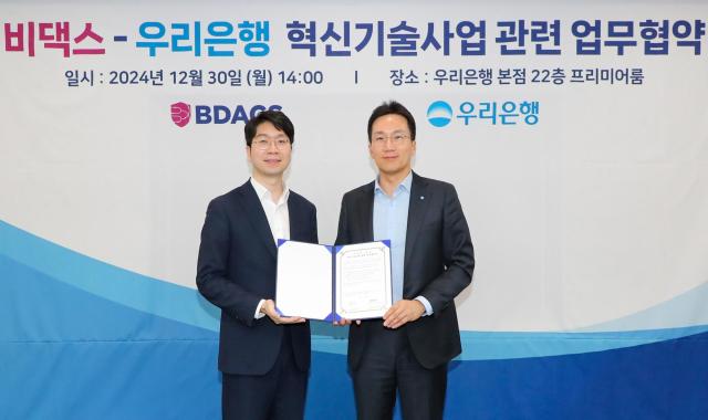 우리은행이 30일 은행 본점에서 비댁스와 혁신기술사업 관련 업무협약MOU 체결 후 옥일진 우리은행 디지털전략그룹장오른쪽 류홍열 비댁스 대표가 기념사진을 촬영하고 있다 사진우리은행
