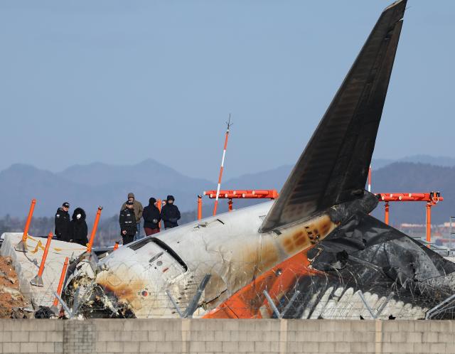 31일 오후 전남 무안군 무안국제공항 제주항공 여객기 참사 현장에서 미국 국가교통안전위원회NTSB 관계자들을 비롯한 한미합동조사단이 기체와 로컬라이저방위각표시시설가 있는 둔덕 등을 살펴보고 있다