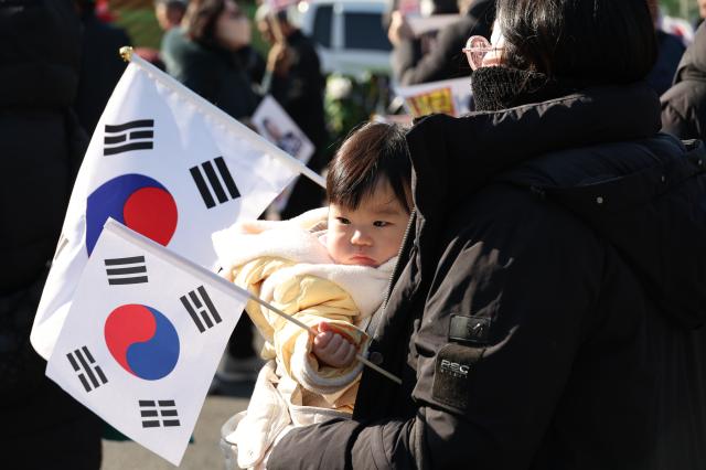 A child holds a Korean national flag at a rally near the Presidential residence in Hannam-dong Seoul on Jan 2 2025 AJP Han Jun-gu