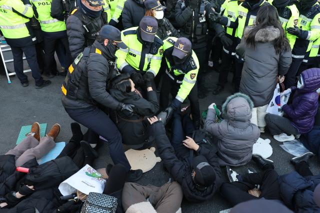 윤석열 대통령에 대한 체포영장 발부 사흘째인 2일 서울 용산구 한남동 대통령 관저 정문 앞 도로에 누워있는 지지자들을 경찰들이 해산시키고 있다 사진연합뉴스