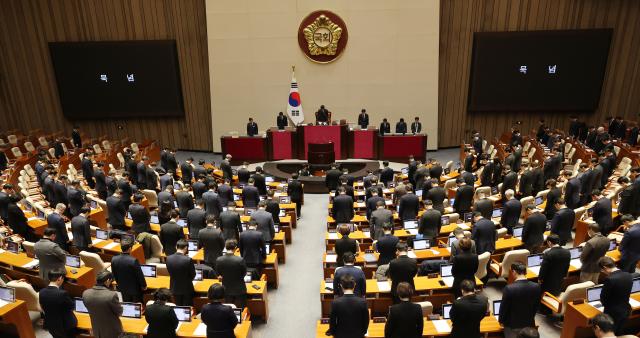 지난달 31일 오후 국회 본회의에서 우원식 국회의장을 비롯한 의원들이 제주항공 여객기 참사 희생자를 추모하며 묵념하고 있다 사진연합뉴스