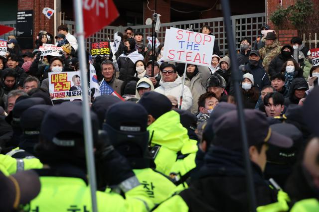 Protesters hold signs near the presidential residence in Hannam-dong Seoul Jan 2 2024 AJP Han Jun-gu