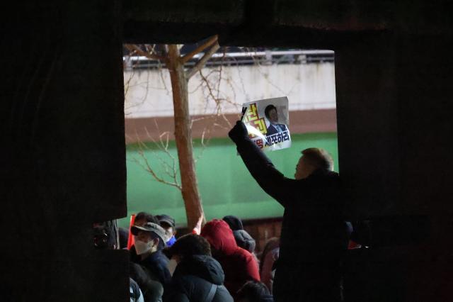 A protester holds a sign near the presidential residence in Hannam-dong Seoul Jan 2 2024 AJP Han Jun-gu