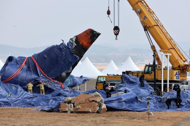 제주항공 여객기 참사 9일째인 6일 오후 전남 무안공항 사고 현장에서 소방ㆍ경찰특공대원들이 강풍에 방수포가 날리지 않게 보강 작업하고 있다 202516 사진연합뉴스