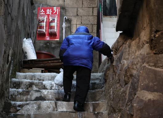 서울 용산구 동자동 쪽방촌에서 한 어르신이 얼음이 언 계단을 힘겹게 오르고 있는 모습 사진연합뉴스