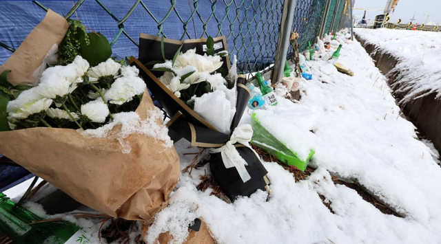 On Jan 8 wreaths and items placed at the accident site fence at Muan International Airport in Muan County South Jeolla Province are covered in white snow Yonhap