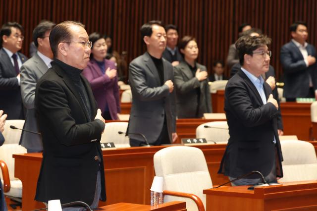 권영세 국민의힘 비상대책위원장과 권성동 원내대표를 비롯한 의원들이 15일 서울 여의도 국회에서 열린 비상 의원총회에서 국기에 경례하고 있다 사진연합뉴스