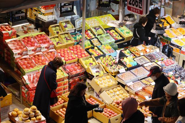 Citizens on Jan 20 pick out fruits at a market in Namdong-gu Incheon ahead of the Lunar New Year Yonhap