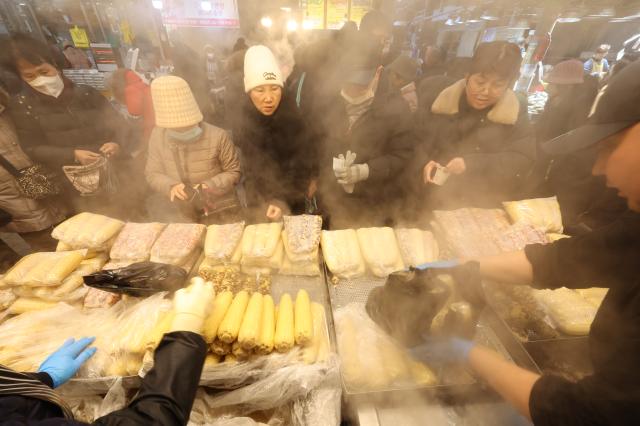 People line up at a steamed corn stand at Kyungdong Market in Seoul AJP Han Jun-gu