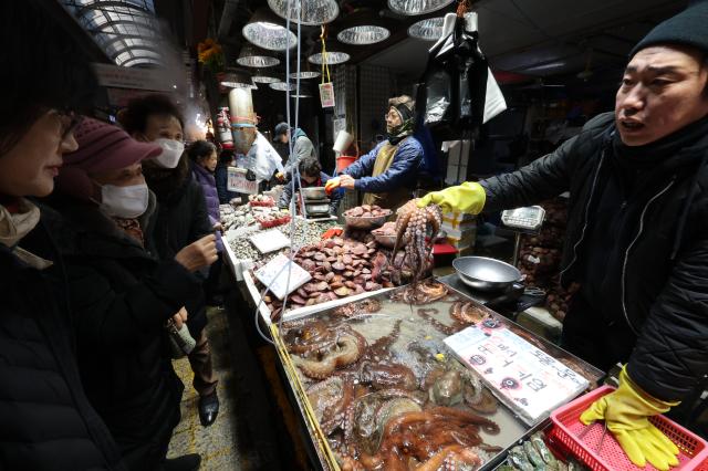 People select octopus at a seafood store in Kyungdong Market in Seoul AJP Han Jun-gu