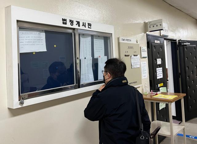 7일 서울중앙지법 경매법정 앞 한 시민이 이날 매각 물건에 대한 정보를 표기한 게시판을 바라보고 있다사진한승구 수습 기자