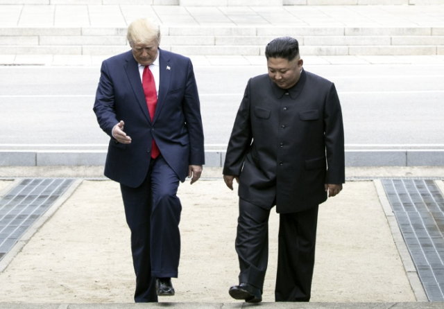 US President Trump and North Korean leader Kim Jong Un walk near the North side of the Demilitarized Zone DMZ in this file photo taken in June 2019 Yonhap