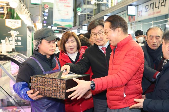 권영세 국민의힘 비상대책위원장과 권성동 원내대표가 설 명절을 앞둔 23일 오후 서울 마포구 망원시장을 방문해 온누리 상품권으로 한우를 구매하고 있다 사진연합뉴스