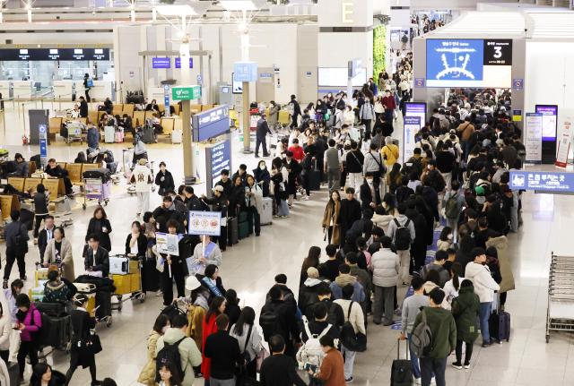 Ahead of the Lunar New Year holiday passengers line up for check-in at the departure area of the 1st terminal of Incheon International Airport on Thursday Yonhap