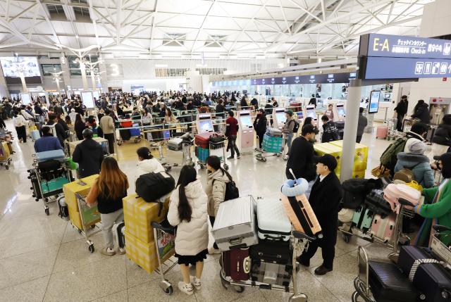 Ahead of the Lunar New Year holiday passengers line up for check-in at the departure area of the 1st terminal of Incheon International Airport on Thursday Yonhap