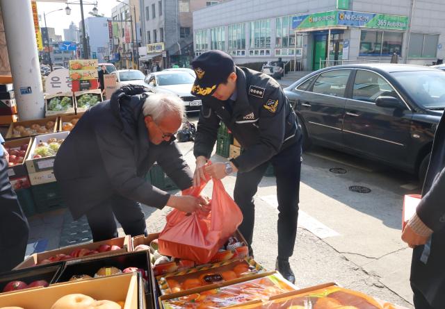 김환경 서장오른쪽이 전통시장을 방문해 과일을 사고있다사진동해해경