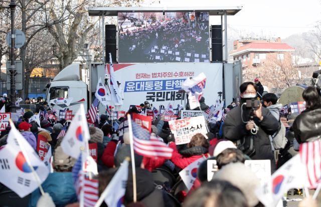 지난 23일 서울 종로구 헌법재판소 인근에서 윤석열 대통령 지지자들이 손팻말을 들고 구호를 외치는 모습 사진연합뉴스