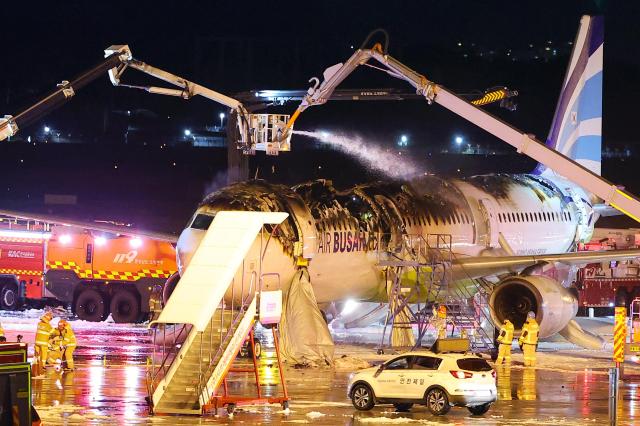 지난 28일 오후 부산 김해국제공항 계류장에서 승객 170명과 승무원 6명을 태우고 이륙을 준비하던 홍콩행 에어부산 항공기 BX391편 꼬리 쪽 내부에서 불이 나 소방대원들이 진화 작업을 하고 있다 사진연합뉴스