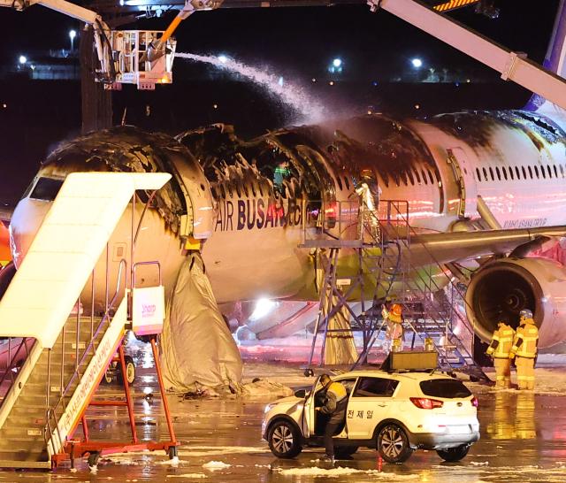 28일 오후 김해공항 계류장에서 승객 170명과 승무원 6명을 태우고 이륙을 준비하던 홍콩행 에어부산 항공기 BX391편 내부에서 불이 나 소방대원들이 진화 작업을 하고 있다 사진연합뉴스