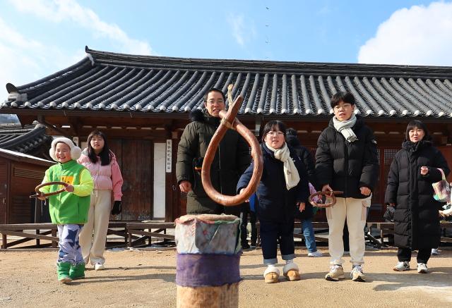  설날인 29일 서울 중구 남산골한옥마을을 찾은 한 가족이 투호를 체험하고 있다 사진연합뉴스