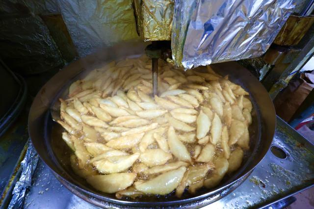 Frying yakimandu fried dumpling at a food stall in Kyungdong Market AJP Han Jun-gu 