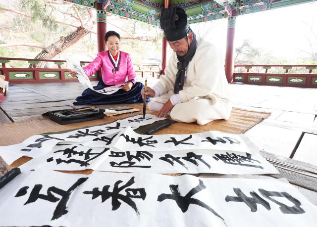  입춘을 하루 앞둔 2일 경기도 용인시 한국민속촌에서 주민들이 입춘첩을 쓰고 있다 YONHAP