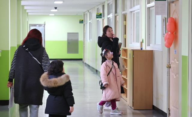  7일 오후 인천 남동구 서창초등학교에서 열린 신입생 예비 소집에서 예비 초등학생이 부모님과 교실을 살펴보고 있다 202517