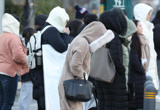 Commuters in Gwanghwamun Seoul bundled up in thick clothing as they headed to work
