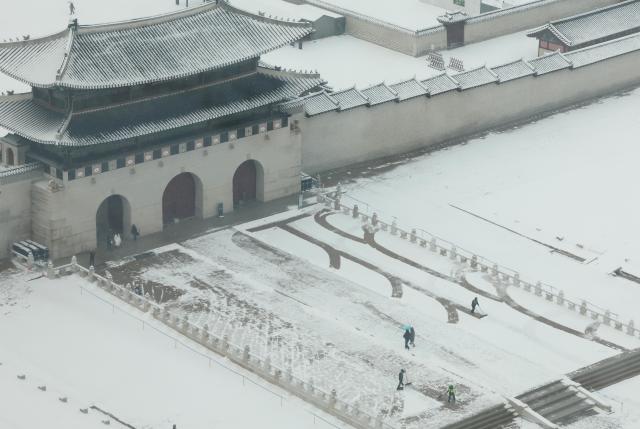 서울 지역에 대설주의보가 내려진 6일 서울 광화문 월대에서 작업자들이 눈을 치우고 있다 사진연합뉴스