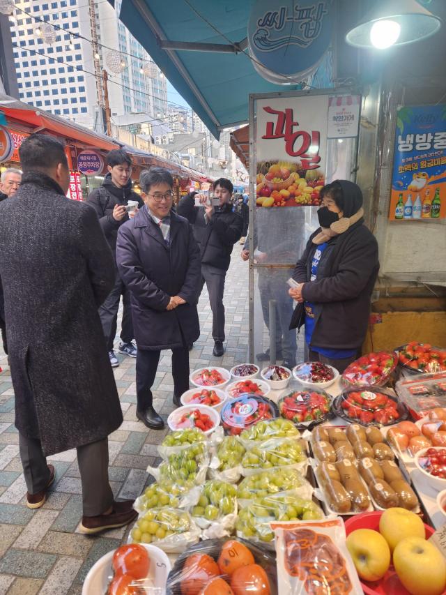 김성섭 중소벤처기업부 차관이 7일 부산 해운대시장을 방문해 온누리상품권으로 물품을 구매하며 상인과 대화를 하고 있다 사진중기부