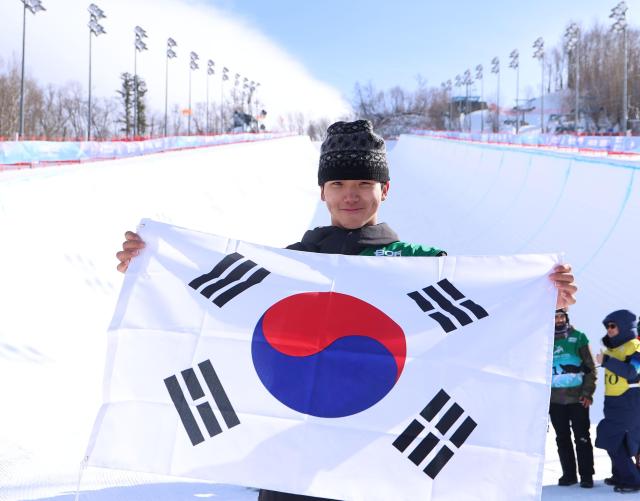 13일 중국 야부리 스키리조트에서 열린 하얼빈 동계아시안게임 스노보드 남자 하프파이프 결선에서 금메달을 차지한 김건희가 태극기를 들고 포즈를 취하고 있다 이날 경기는 강풍으로 취소돼 김건희는 예선 성적 78점으로 1위를 확정했다 사진연합뉴스