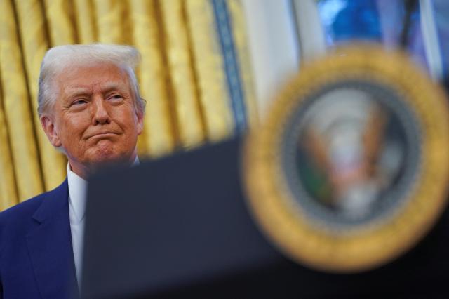 US President Donald Trump looks on during Tulsi Gabbards swearing in ceremony as Director of National Intelligence in the Oval Office at the White House in Washington DC Feb 12 2025 Reuters-Yonhap