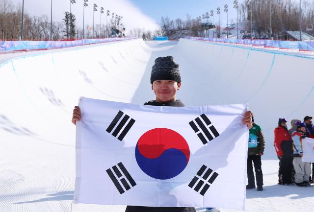 13일 중국 야부리 스키리조트에서 열린 하얼빈 동계아시안게임 스노보드 남자 하프파이프 결선에서 금메달을 차지한 김건희가 태극기를 들고 포즈를 취하고 있다 이날 경기는 강풍으로 취소돼 김건희는 예선 성적 78점으로 1위를 확정했다 사진연합뉴스