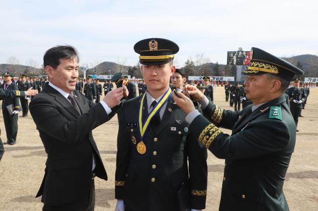 김선호 국방부장관 직무대행왼쪽과 박성훈 육군3사관학교장오른쪽이 대통령상을 수상한 이상훈 소위에게 계급장을 수여하고 있는 모습 사진육군
