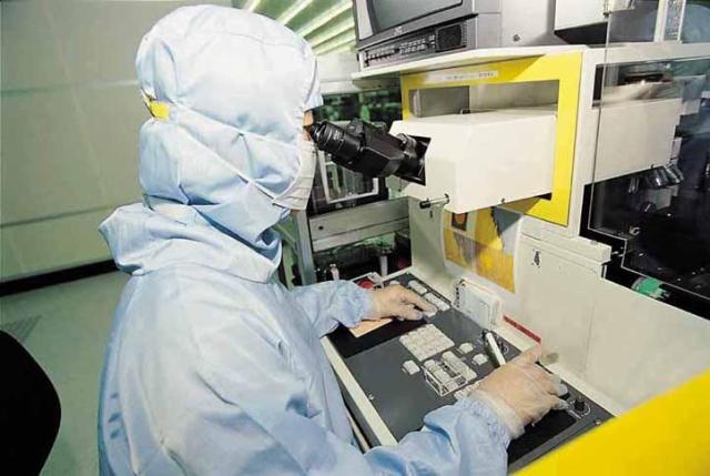 A TSMC engineer working on 8 inch wafers in a fabrication facility also called fab Courtesy of TSMC