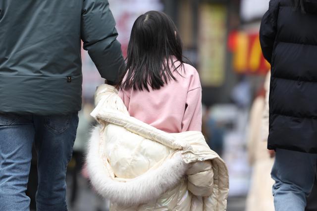 포근한 날씨를 보인 28일 서울 중구 명동 거리에서 한 아이가 외투를 반쯤 입은 채로 이동하고 있다 2025228 사진연합뉴스