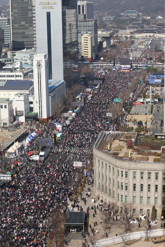 8일 서울 종로구 광화문 일대에서 열린 탄핵 반대 집회에서 참가자들이 태극기와 손팻말을 흔들고 있다 사진연합뉴스