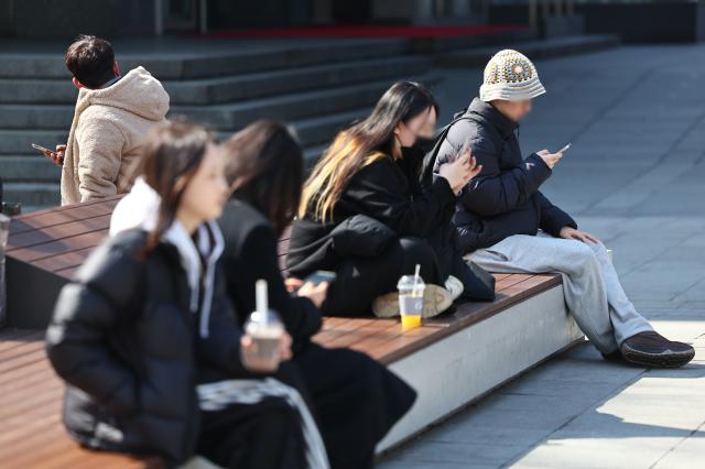 서울 낮 최고기온이 10도까지 오른 6일 서울 종로구 광화문광장에서 시민들이 벤치에 앉아 쉬고 있다 사진연합뉴스