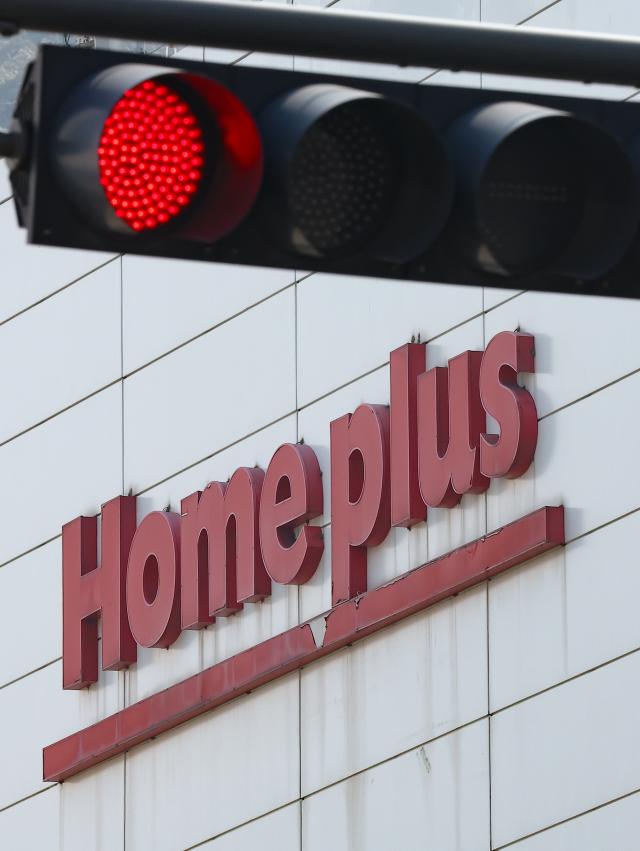 Logo of Homeplus under a red traffic light Yonhap